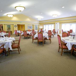 A spacious dining room with elegantly set tables and chairs, featuring a formal ambiance.