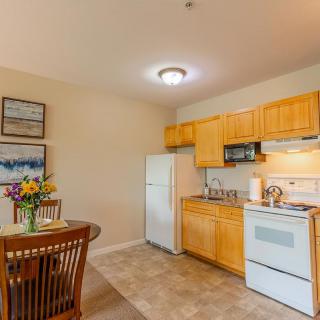 A cozy kitchen and dining area with wooden cabinets in a modern apartment.