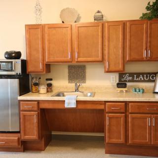 A cozy kitchen interior featuring wooden cabinets and modern appliances.