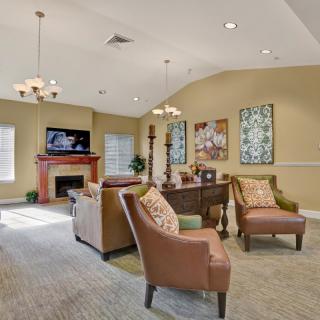 A cozy living room with comfortable seating, a fireplace, and decorative wall art.
