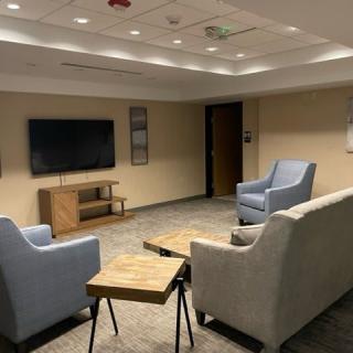 A modern and cozy living room with comfortable seating and a flat-screen TV.