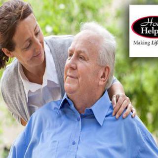 A caregiver providing support and companionship to an elderly man outdoors.