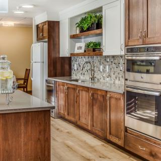 A modern kitchen with wood cabinets, stainless steel appliances, and decorative backsplash.