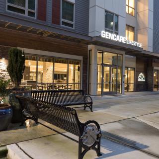 Entrance to a commercial building at night with a bench in front.