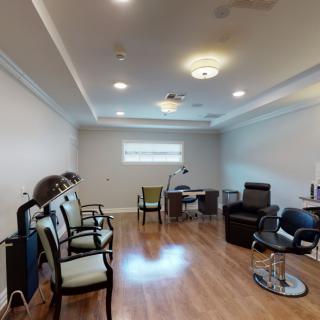 A bright and spacious salon interior with seating and workstations.