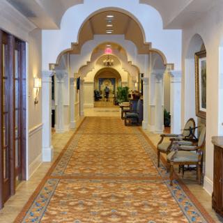 A beautifully designed hallway featuring elegant arches and patterned flooring, leading to a welcoming space.
