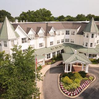 Aerial view of a residential building with green rooftops and landscaped entrance.
