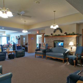 A spacious and cozy living room with ample seating, featuring blue sofas and a brick fireplace.