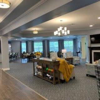 A spacious and elegantly decorated living area featuring comfortable seating, a fireplace, and ample natural light from large windows.