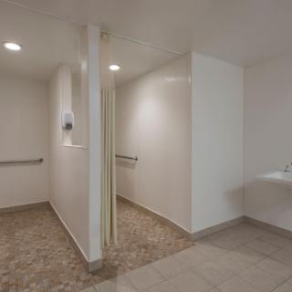 A clean and modern restroom featuring white walls, an accessible sink, and thoughtful design elements.
