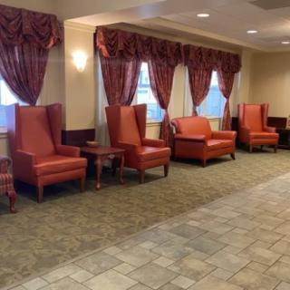 A lobby seating area featuring red upholstered chairs and matching curtains.