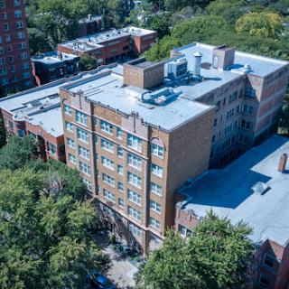 Aerial view of a multi-story residential building surrounded by greenery.