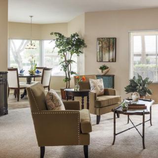 A cozy living space featuring comfortable seating, a dining area, and natural light with greenery.
