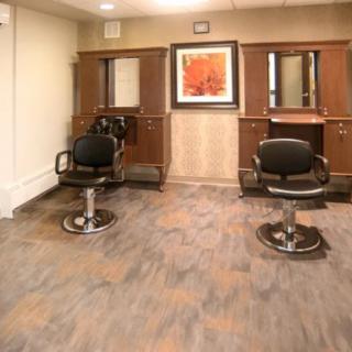 A clean and modern salon interior with two hairstyling stations featuring chairs and mirrors.