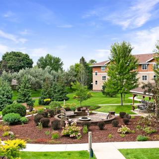 A beautifully landscaped garden with pathways and green surroundings near a residential building.