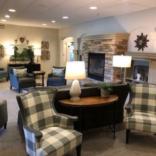 A cozy living room with comfortable seating, lamps, and a fireplace.