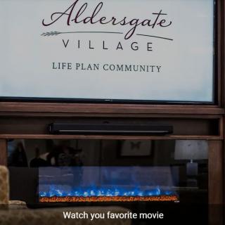 A cozy setup at Aldersgate Village, a life plan community, with a fireplace and screen inviting you to watch your favorite movie.
