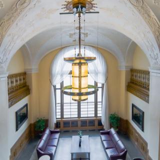 A beautifully designed interior space featuring a large chandelier, arched ceiling, and elegant seating area by a window.