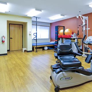 A spacious fitness room equipped with various exercise machines and equipment.