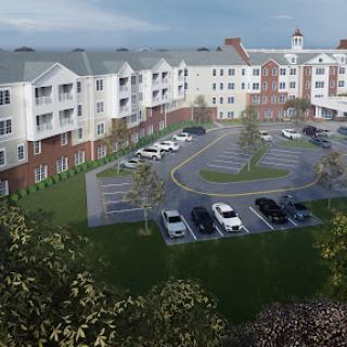 A modern residential apartment complex featuring landscaped grounds and a parking area.