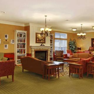A cozy living room with comfortable seating, a fireplace, and bookshelves.