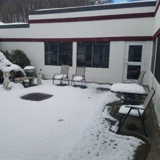 A snow-covered courtyard with patio furniture during winter.