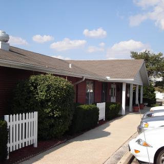 A view of a residential building with a well-maintained exterior and surrounding greenery.