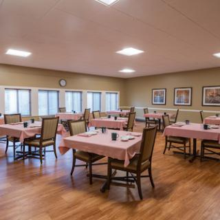 A spacious dining area with neatly set tables and a warm, welcoming atmosphere.