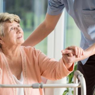 A caregiver assisting an elderly person.