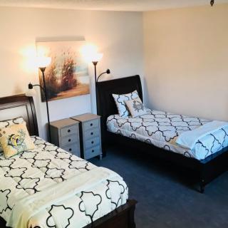 A cozy bedroom with twin beds and modern decor.