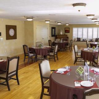 A cozy dining area with neatly arranged tables and chairs, set for a meal.