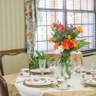 A beautifully arranged dining table with a floral centerpiece in an elegantly decorated room.