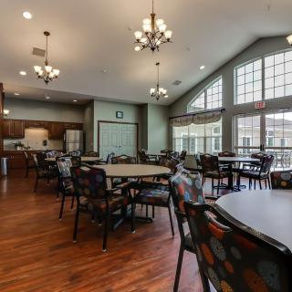 Spacious dining area with large windows and chandeliers.