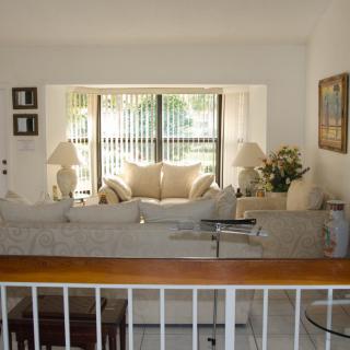 A cozy living room with natural light streaming through large windows, featuring a comfortable sofa and elegant decor.