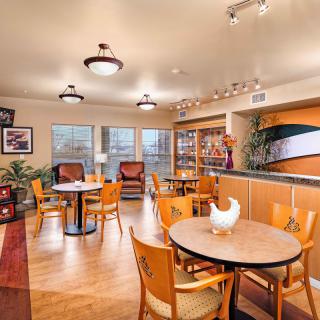 A cozy dining area with tables and chairs, decorated with warm lighting.