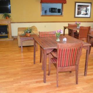 A cozy dining area featuring wooden tables and chairs, adorned with small plants.