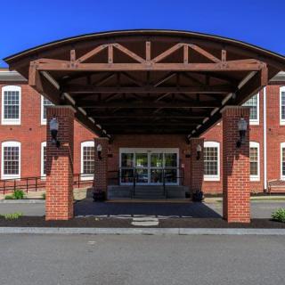 A symmetrical building entrance with a brick facade and wooden canopy.