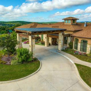A luxurious countryside house with a spacious driveway and beautiful landscaping.