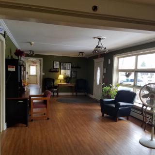 A cozy living room with seating arrangements and large windows.