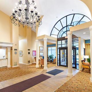 A spacious and elegantly designed lobby featuring a large chandelier and welcoming entrance.