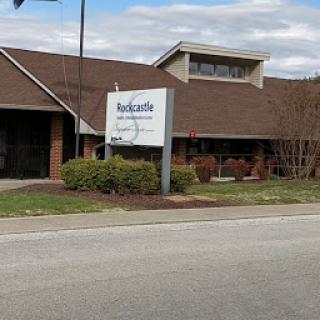 A view of a business building from the roadside, featuring a clear sign.