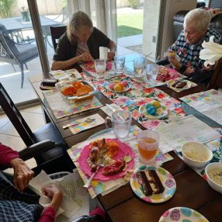 A delightful social gathering with friends, enjoying a variety of colorful snacks and meals at the dining table.