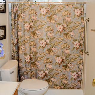 A bathroom featuring a floral pattern shower curtain and modern fixtures.
