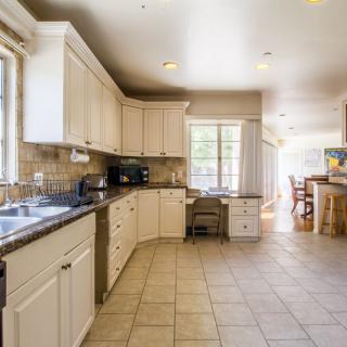 Spacious kitchen with white cabinets, ample counter space, and a dining area.