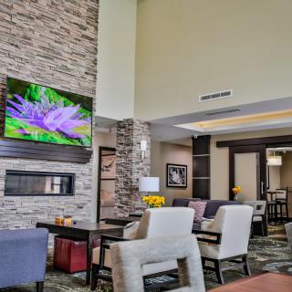 A modern lobby with comfortable seating and a large television display.