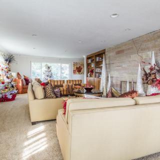 A cozy living room decorated for the holidays with a Christmas tree and warm furnishings.