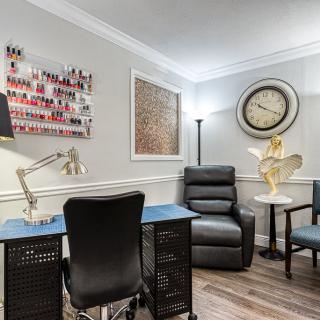 A cozy nail salon interior featuring a manicure station, recliner chair, and stylish decor.