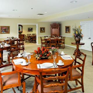 An elegantly set dining room with several tables and chairs, featuring stylish decor.