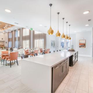 A modern kitchen and dining area with stylish pendant lights and an island countertop.
