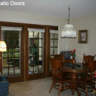 Cozy dining room with wooden furniture and glass patio doors.